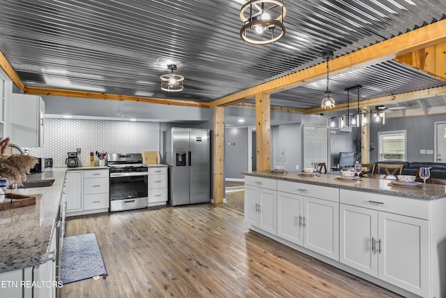 kitchen with white cabinetry, sink, stainless steel appliances, and dark stone counters