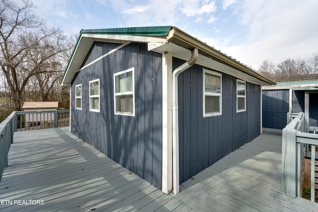 view of side of property with a wooden deck and an outdoor structure