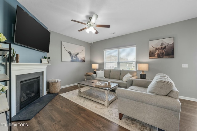 living room featuring dark wood-type flooring and ceiling fan