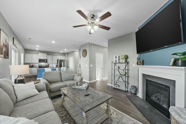 living room with dark hardwood / wood-style floors and ceiling fan