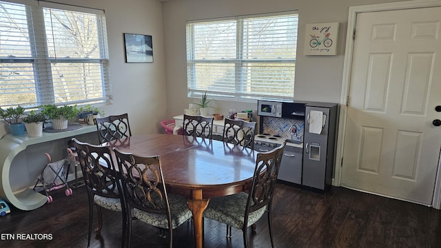 dining space with plenty of natural light and dark hardwood / wood-style floors