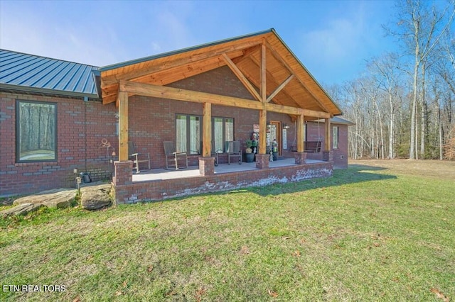 rear view of house featuring a patio area and a lawn