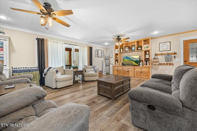 living room featuring ornamental molding, wood-type flooring, and ceiling fan