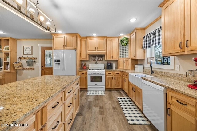 kitchen featuring light stone counters, white appliances, light brown cabinetry, and sink