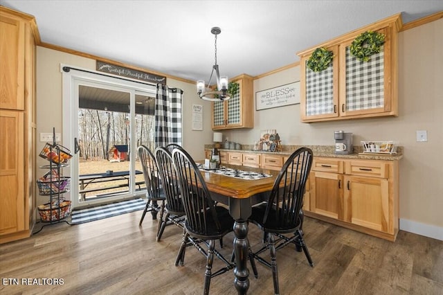 dining area with dark hardwood / wood-style flooring, a notable chandelier, and ornamental molding