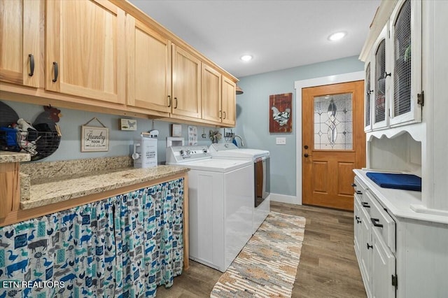 laundry area featuring cabinets, separate washer and dryer, and light wood-type flooring