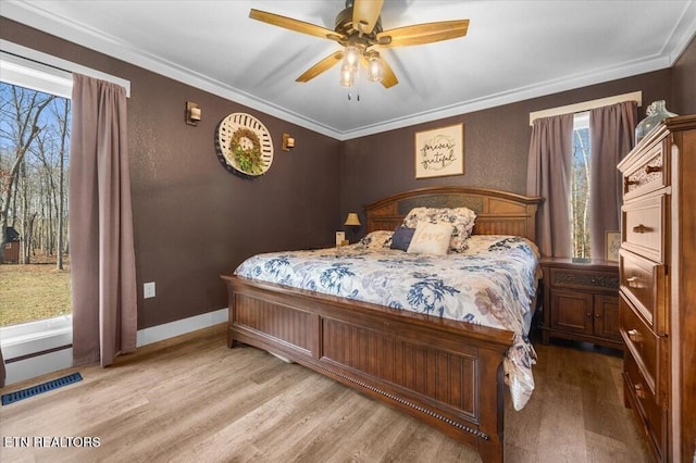 bedroom featuring crown molding, light hardwood / wood-style flooring, and ceiling fan