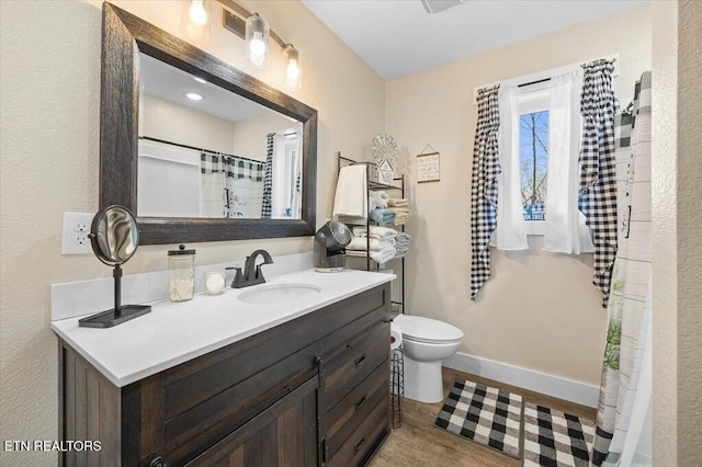 bathroom with vanity, hardwood / wood-style floors, and toilet