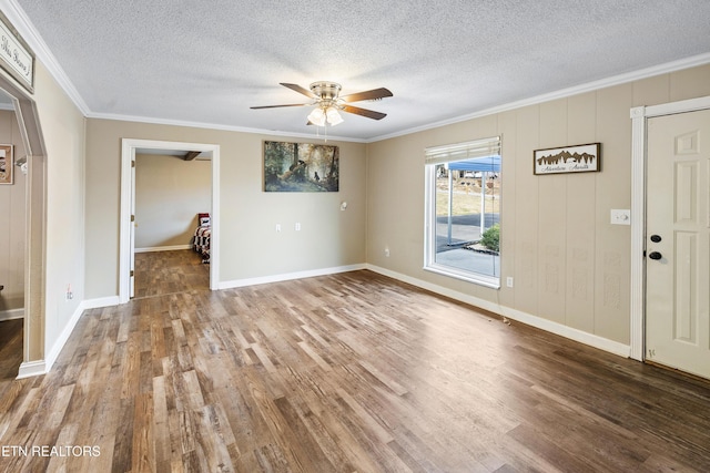 interior space with wood-type flooring, ornamental molding, and ceiling fan