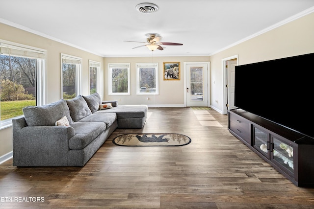 living room with dark wood-type flooring, ornamental molding, and ceiling fan