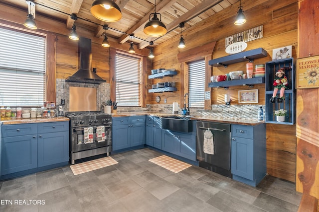 kitchen with wood walls, island exhaust hood, appliances with stainless steel finishes, and decorative light fixtures