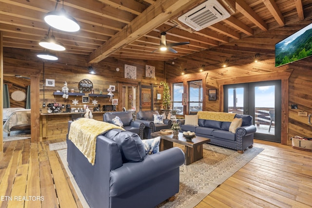 living room featuring french doors, light wood-style floors, wood ceiling, wood walls, and beamed ceiling