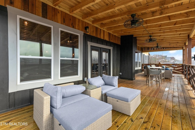 wooden deck with ceiling fan, french doors, and outdoor dining space