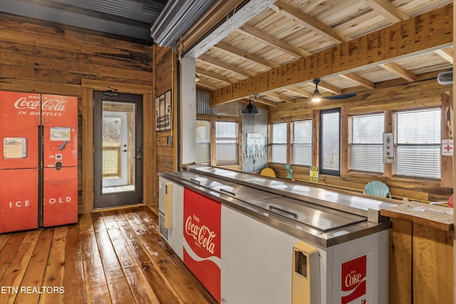 kitchen featuring wood walls, wood ceiling, dark wood-type flooring, and beam ceiling