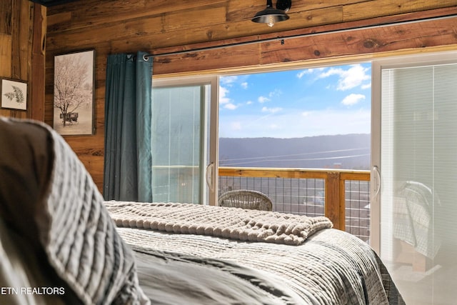 bedroom with wood walls and a mountain view