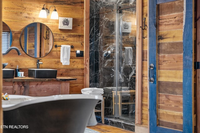 full bath featuring a soaking tub, wooden walls, and vanity