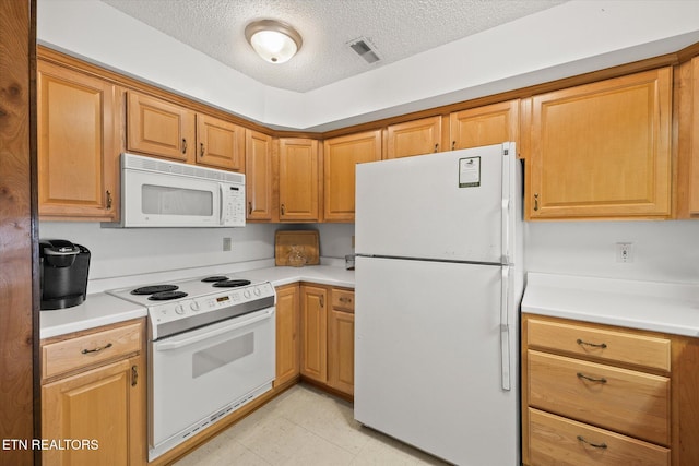 kitchen featuring a textured ceiling, light countertops, white appliances, and visible vents