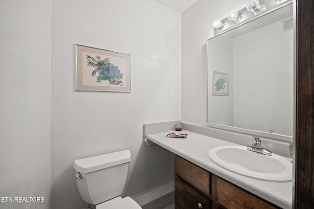 bathroom with visible vents, vanity, and toilet