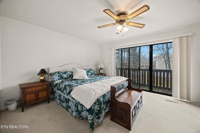 bedroom featuring access to exterior, light colored carpet, visible vents, a ceiling fan, and a textured ceiling