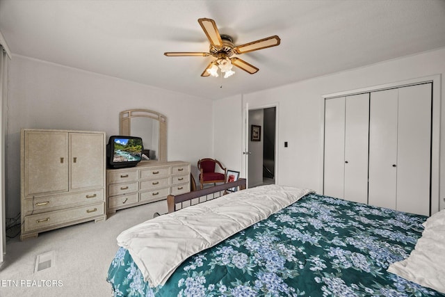 bedroom with light carpet, visible vents, a closet, and a ceiling fan