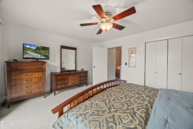 bedroom with light carpet, a closet, and a ceiling fan