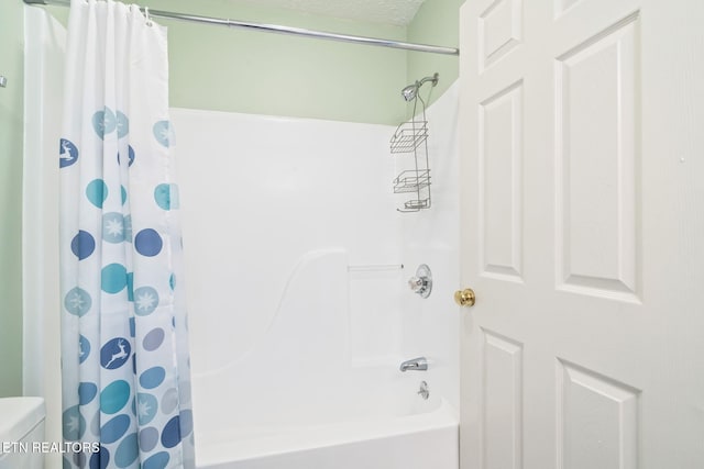 bathroom featuring shower / bathtub combination with curtain and a textured ceiling