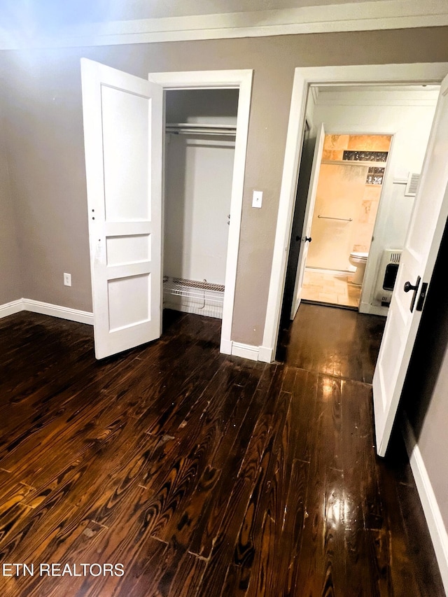 unfurnished bedroom featuring dark hardwood / wood-style flooring and a closet