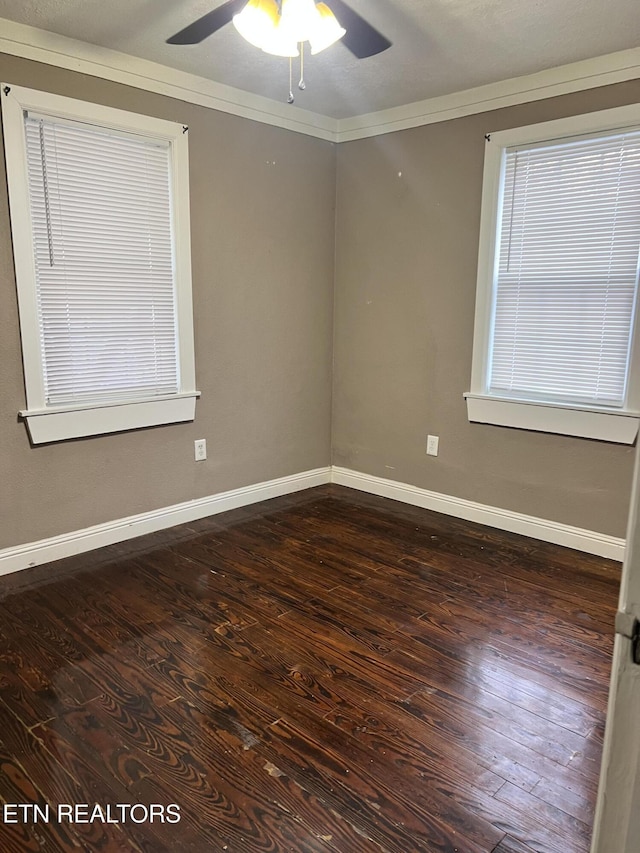 empty room featuring crown molding, dark wood-type flooring, and ceiling fan