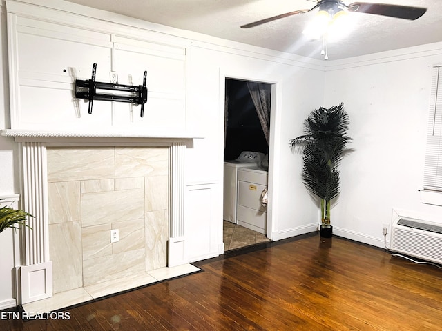 interior space with ceiling fan, dark hardwood / wood-style floors, a wall mounted AC, and independent washer and dryer