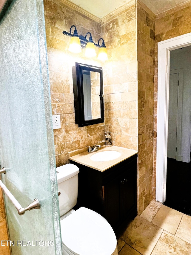 bathroom with vanity, tile walls, and toilet