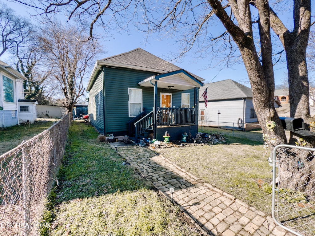 bungalow featuring covered porch and a front lawn