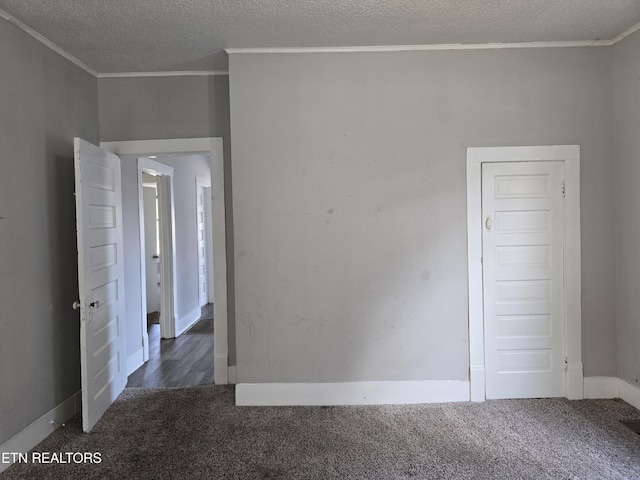 spare room featuring crown molding and dark carpet