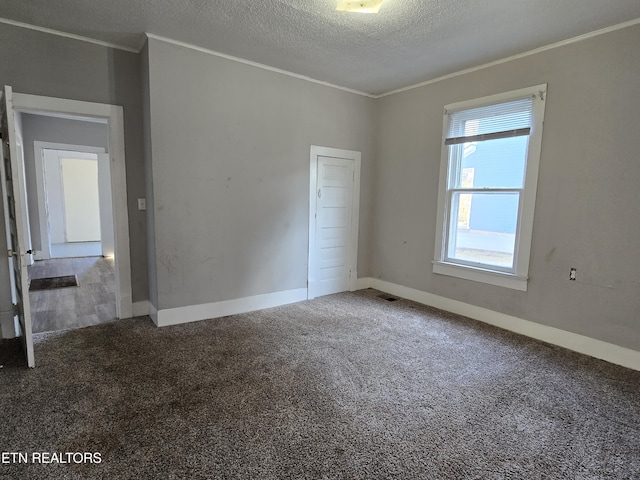 carpeted spare room with crown molding and a textured ceiling