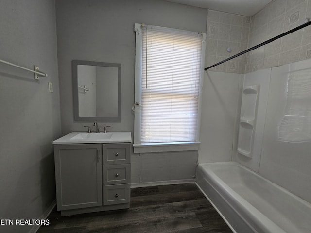 bathroom with wood-type flooring, vanity, and washtub / shower combination