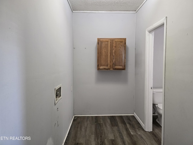 interior space featuring dark wood-type flooring, washer hookup, and a textured ceiling