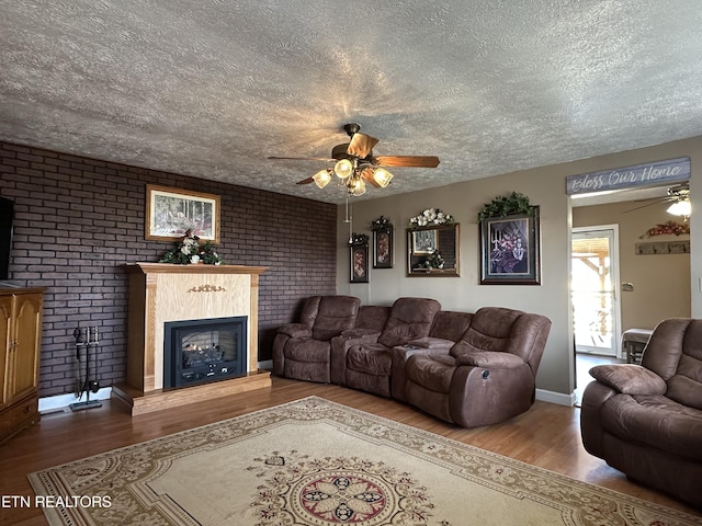 living room featuring hardwood / wood-style floors, a textured ceiling, and ceiling fan