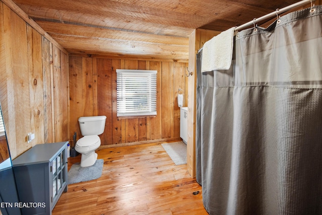 bathroom with toilet, wood ceiling, wooden walls, and wood finished floors