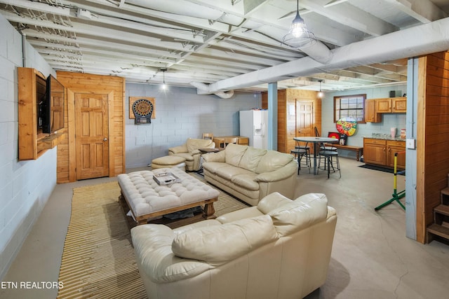 living room featuring concrete flooring and concrete block wall