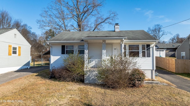 bungalow-style house with a porch and a front lawn