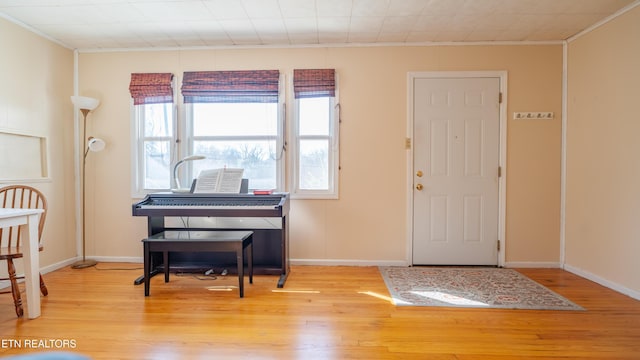 entrance foyer with ornamental molding and light wood-type flooring