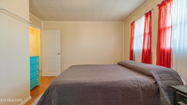 bedroom featuring hardwood / wood-style flooring and ornamental molding