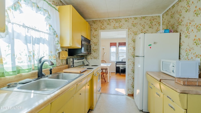 kitchen with sink, white appliances, and ornamental molding