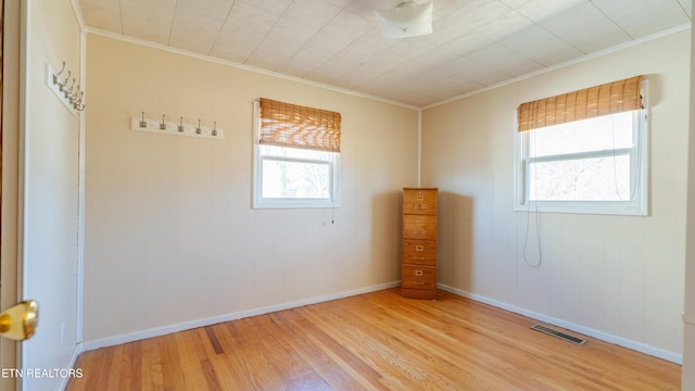 unfurnished room featuring crown molding and light wood-type flooring