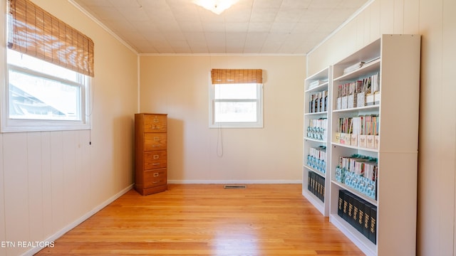 empty room featuring ornamental molding and light hardwood / wood-style flooring