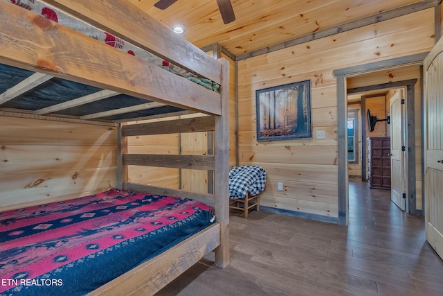 bedroom featuring wooden walls, wooden ceiling, and dark hardwood / wood-style floors