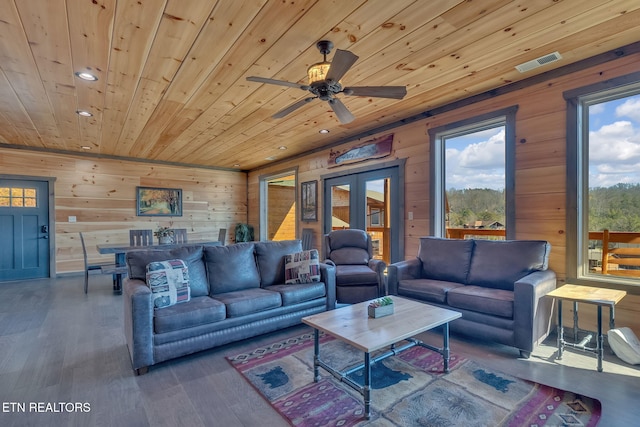 living room featuring hardwood / wood-style flooring, ceiling fan, wood ceiling, and wood walls