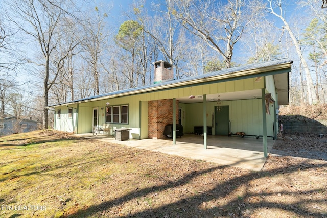 back of property with a yard and a patio area