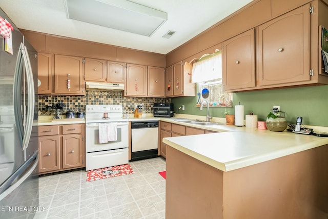 kitchen featuring sink, backsplash, white appliances, and kitchen peninsula