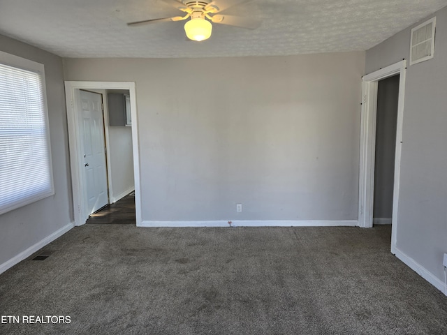 carpeted spare room with ceiling fan and a textured ceiling