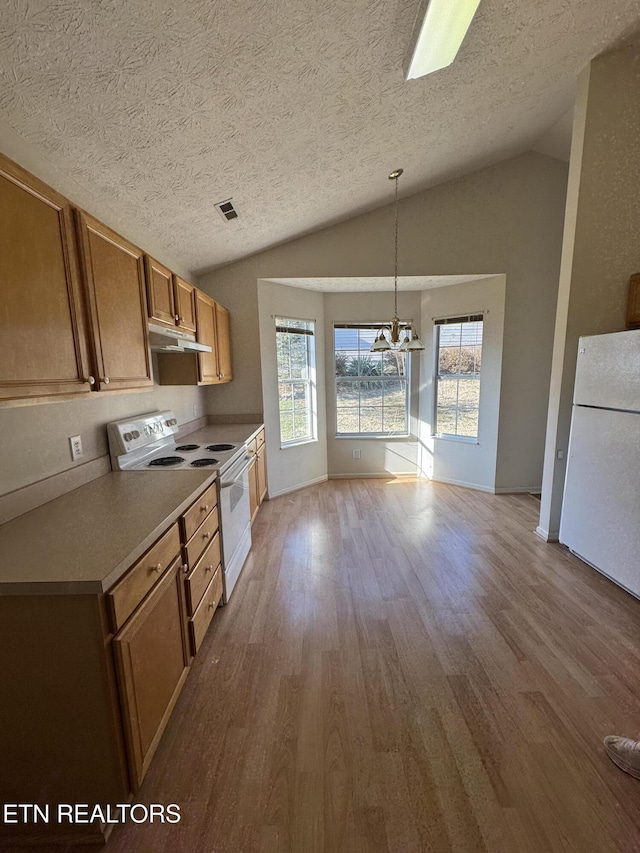 kitchen with decorative light fixtures, lofted ceiling, white appliances, a textured ceiling, and light hardwood / wood-style flooring